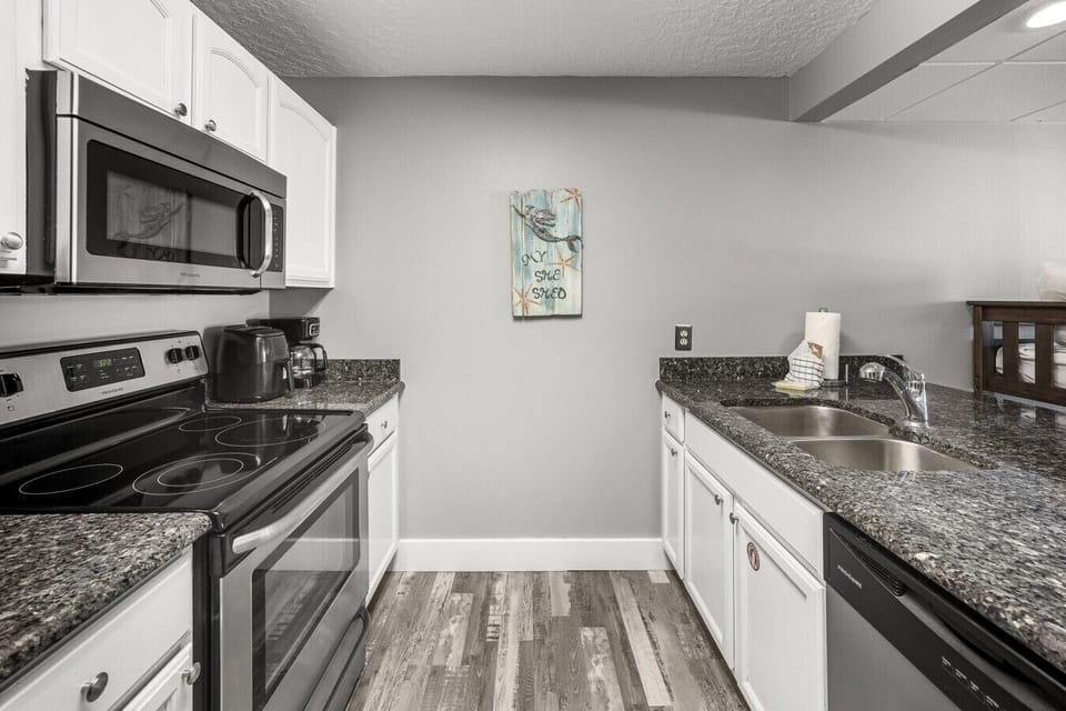 Fully equipped and ready for your stay, this modern kitchen includes granite countertops, stainless steel appliances, and all the essentials to cook up something delicious.