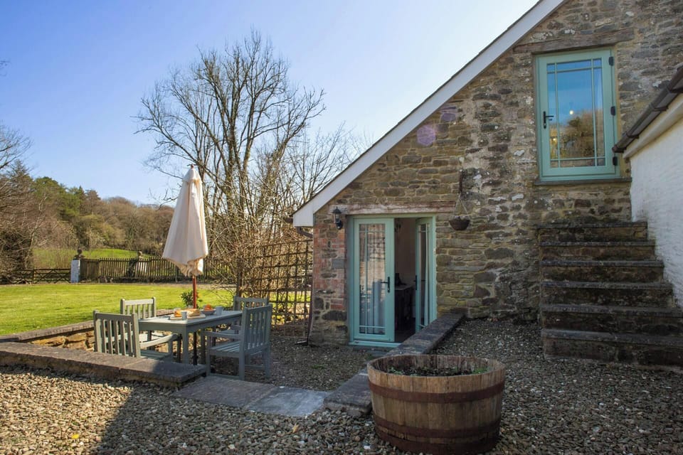 Doors leading from the cottage to a patio area with table and chairs