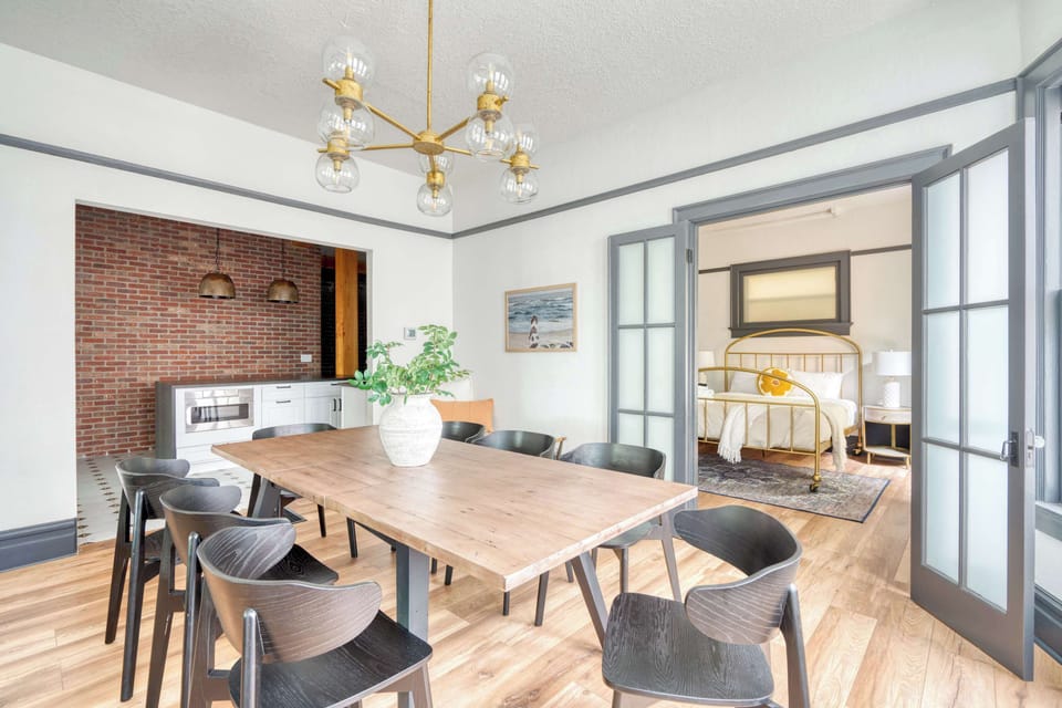 Dining table with a doorway into the brass-bed bedroom.