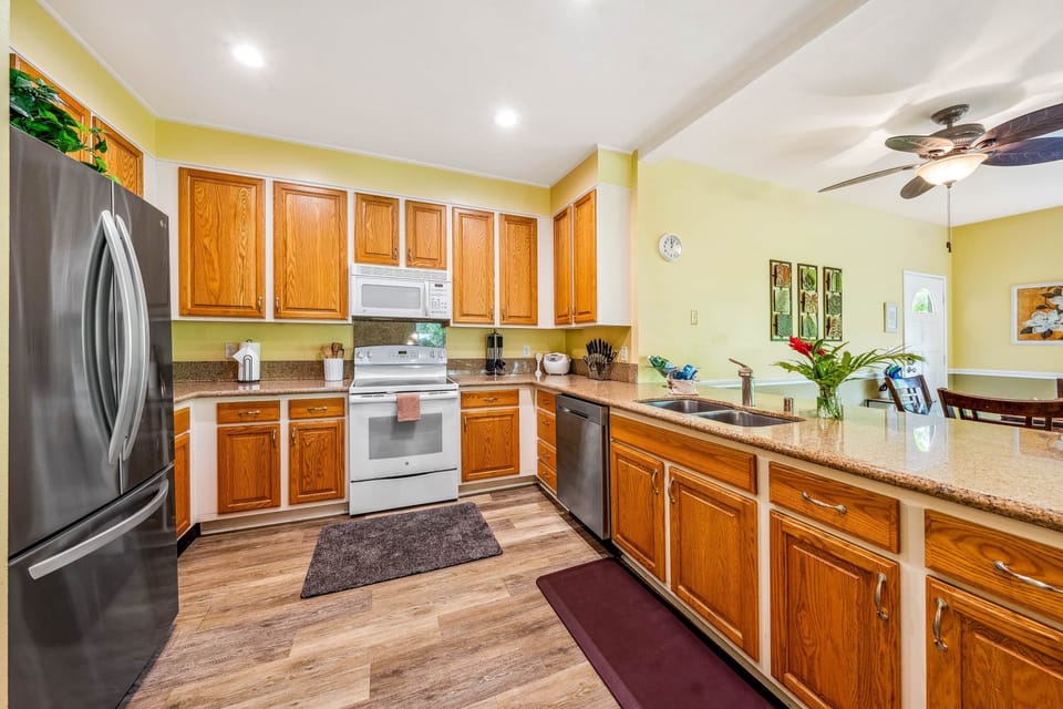 Modern kitchen featuring warm wooden cabinets, granite countertops, and stainless steel appliances.