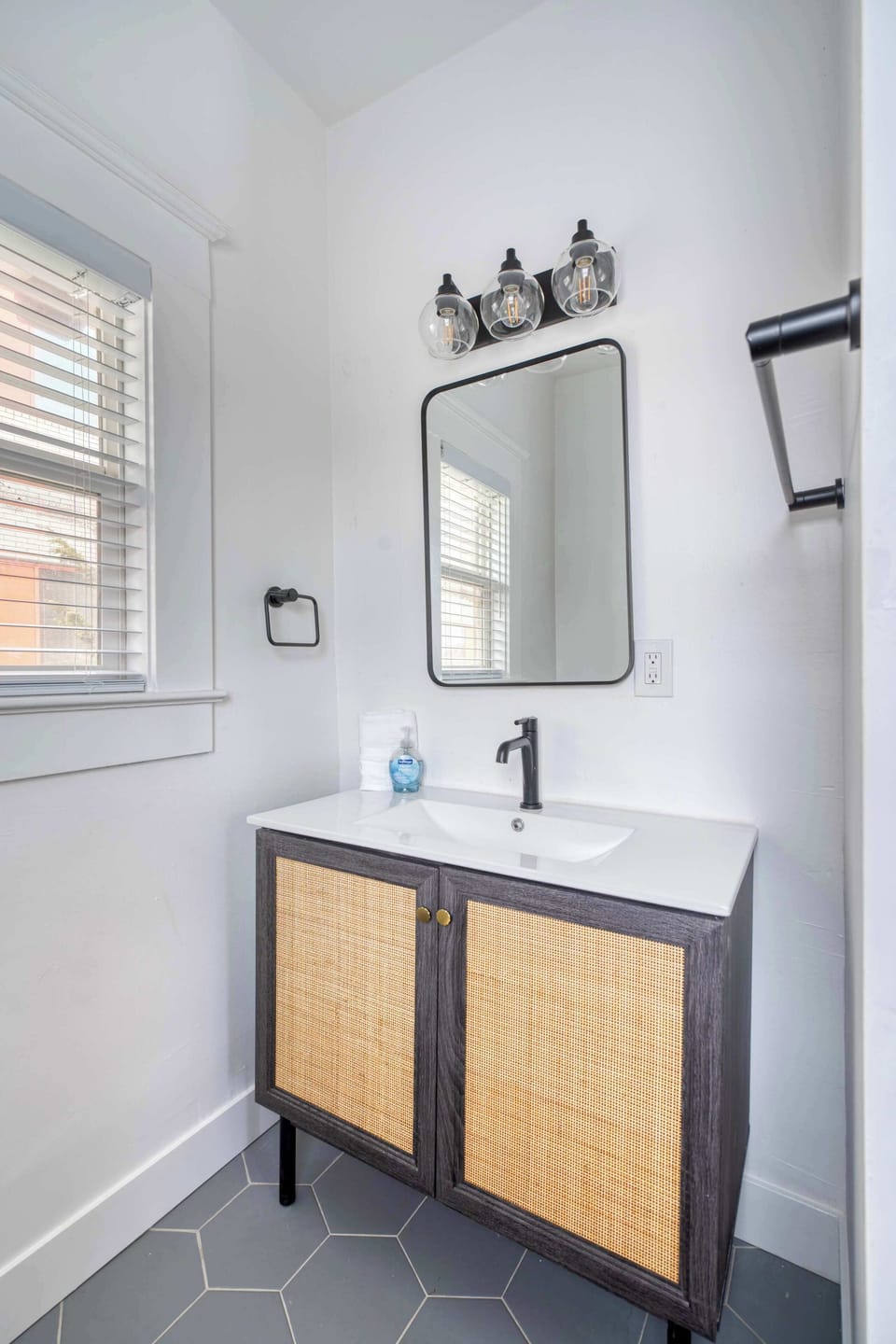 Bathroom with sink, mirror and window.
