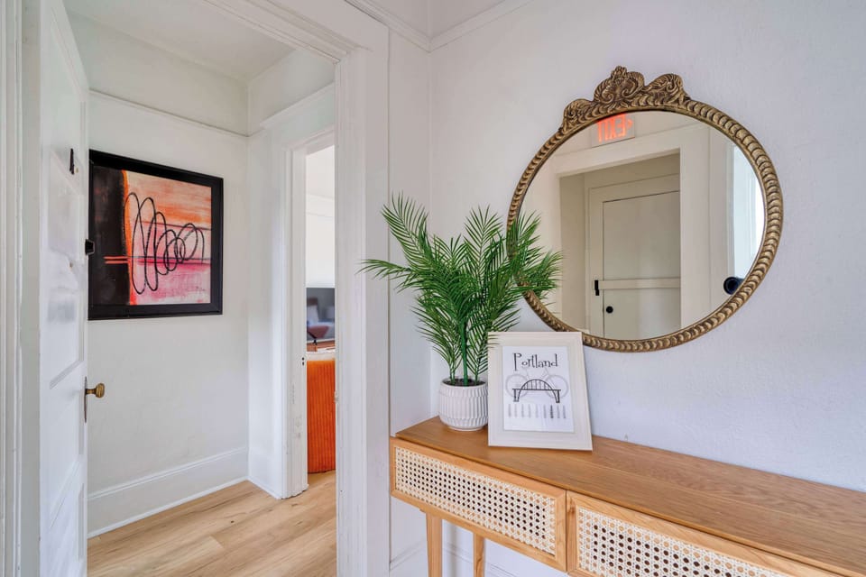 Entry with cane console, mirror, and artwork.