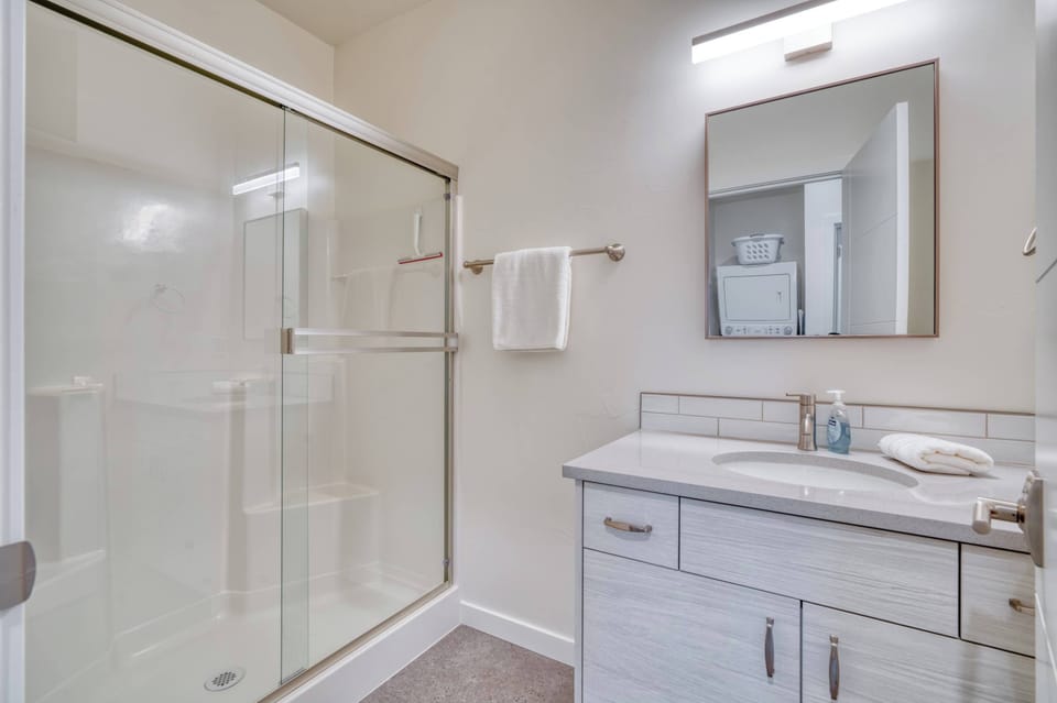 Glass-enclosed shower beside the bathroom vanity.