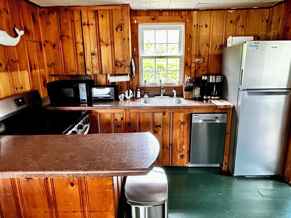 Kitchen is fully stocked with dishes, utensil, pots, and pans.