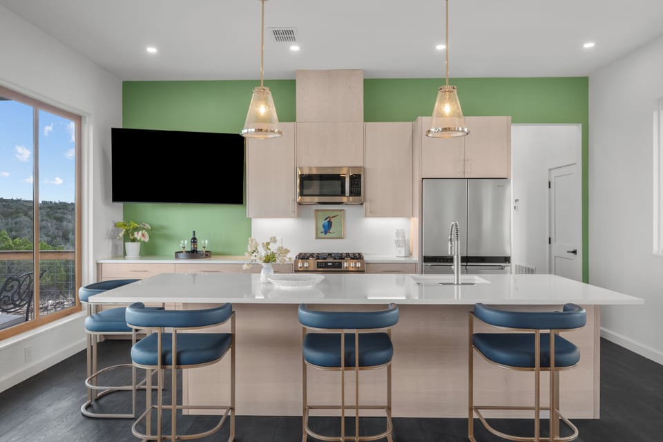 Large kitchen island with barstools for watching TV or dining.
