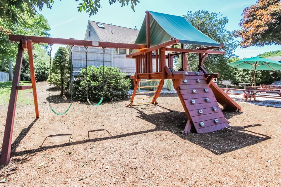 The outdoor playground features swings and climbing structures, providing a safe and enjoyable space for children to play.