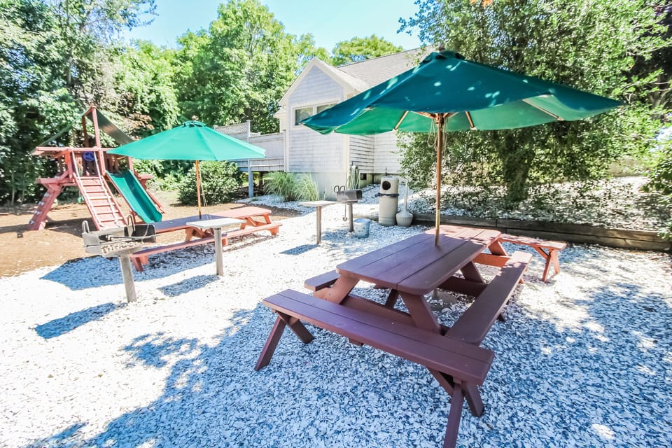 The family-friendly BBQ area offers picnic tables and a playground, creating the perfect setting for outdoor meals and joyful playtime.