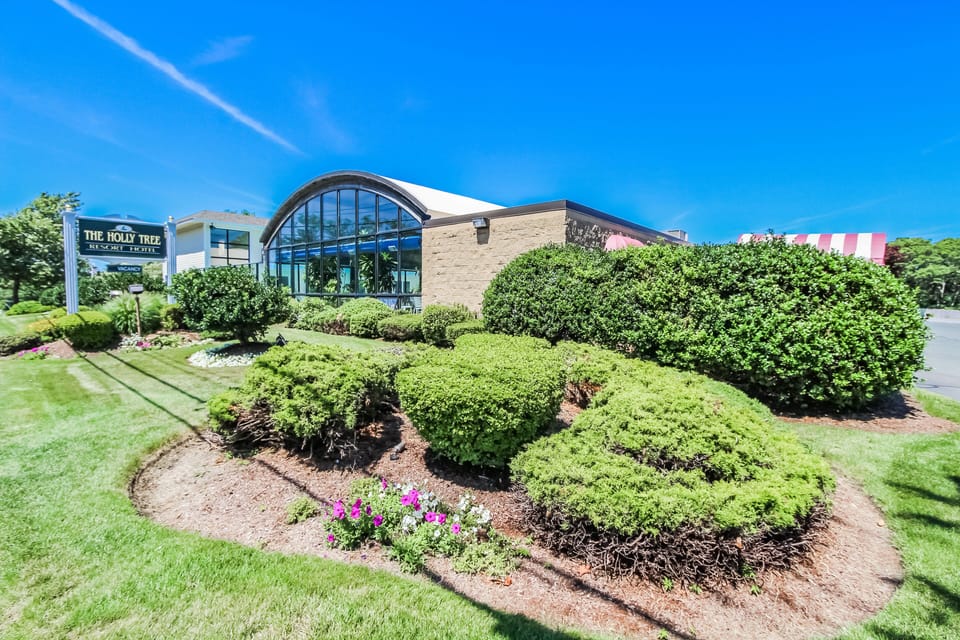 The Holly Tree Resort welcomes you with its charming architecture and lush landscaping, providing a delightful start to your Cape Cod getaway.