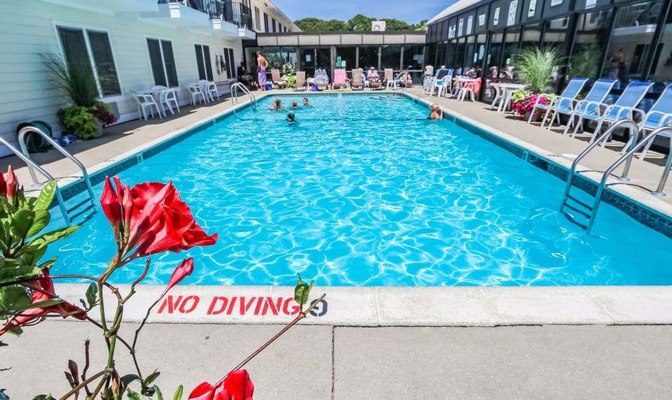 Relax by the inviting outdoor pool surrounded by beautiful flowers, perfect for family fun under the sun at this cozy Cape Cod condo.