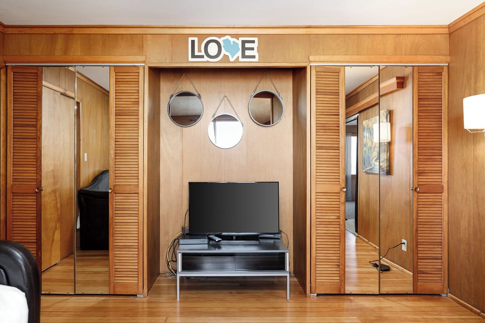 Entertainment nook w/ TV & sliding wood doors adding rustic character.