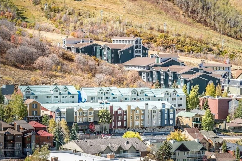 This scenic view showcases modern mountain decor and convenient walk-to-lift ski access in a charming cluster of lodges nestled against a colorful hillside.