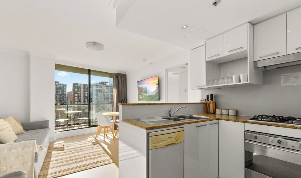A clean and tidy U-shaped kitchen featuring white cabinetry