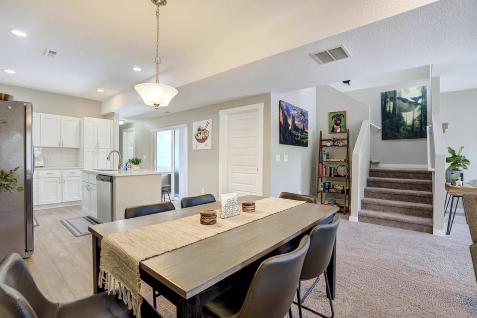 Gather around the stylish dining table with views into the bright kitchen—ideal for sharing meals, playing games, or planning your next outing.








