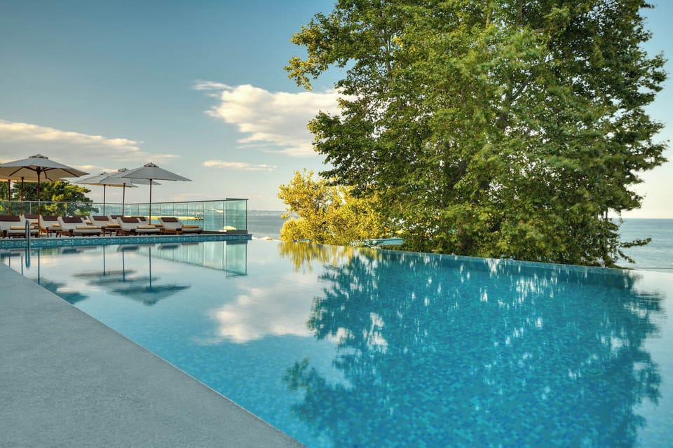 Seasonal outdoor pool, an infinity pool, pool umbrellas, sun loungers