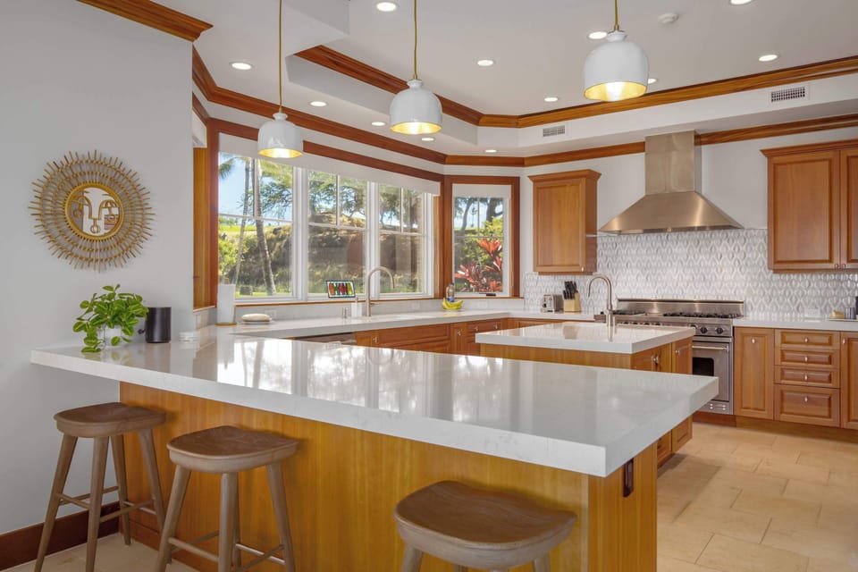 To the side of the kitchen is a bar counter with seating for 3