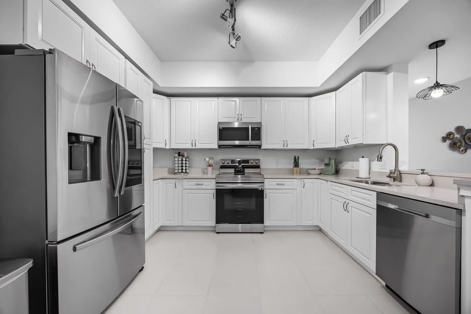 Modern kitchen with stainless steel appliances and white cabinetry