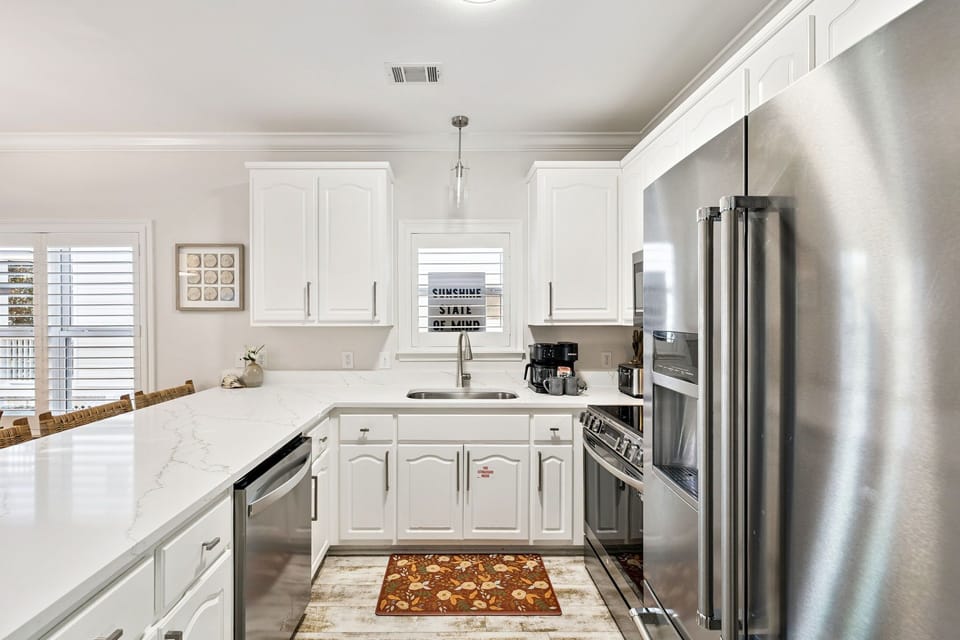 Your gourmet kitchen awaits with gleaming granite counters, stainless steel appliances, and crisp white cabinetry perfect for preparing memorable meals.