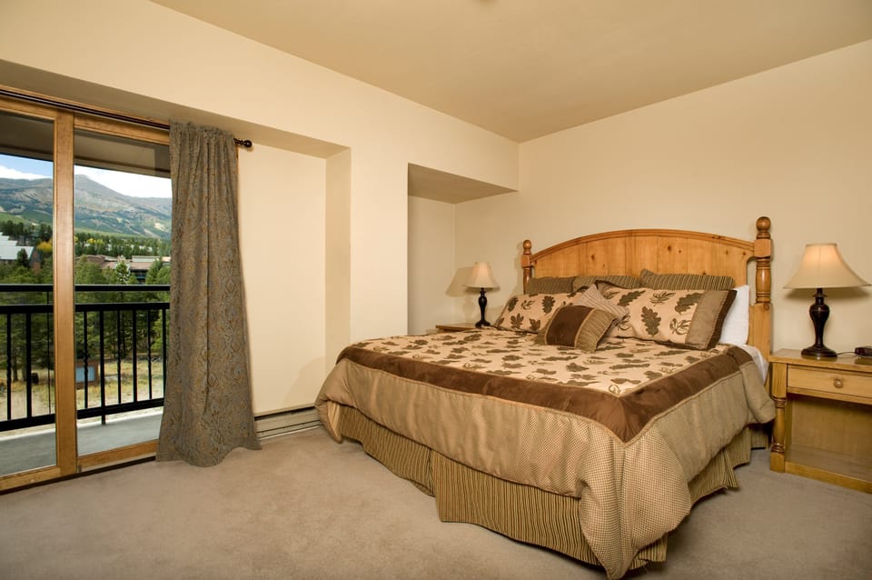 The master bedroom features a queen bed and access to the private balcony
