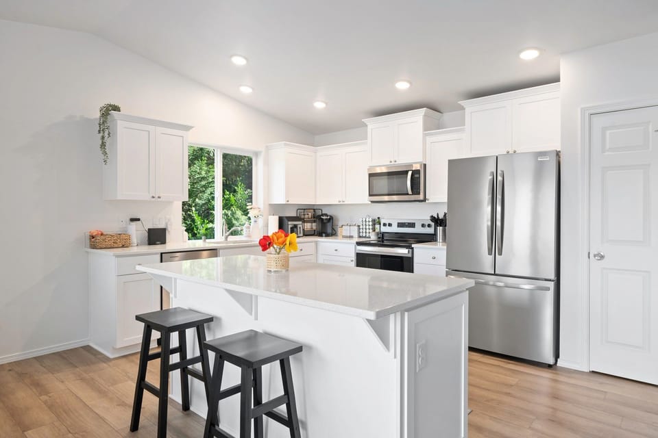 Cook, dine, and connect with ease in this modern kitchen featuring bar seating and high-end appliances—perfect for casual mornings or festive nights in.