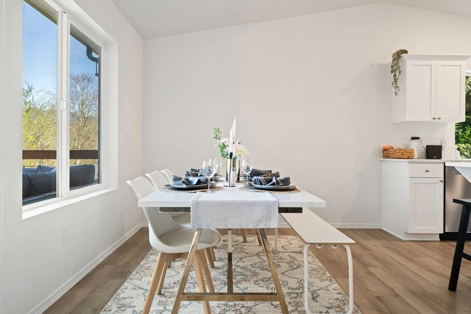 Enjoy intimate meals with lake views at this cozy dining table, where natural light and simplicity enhance every bite.