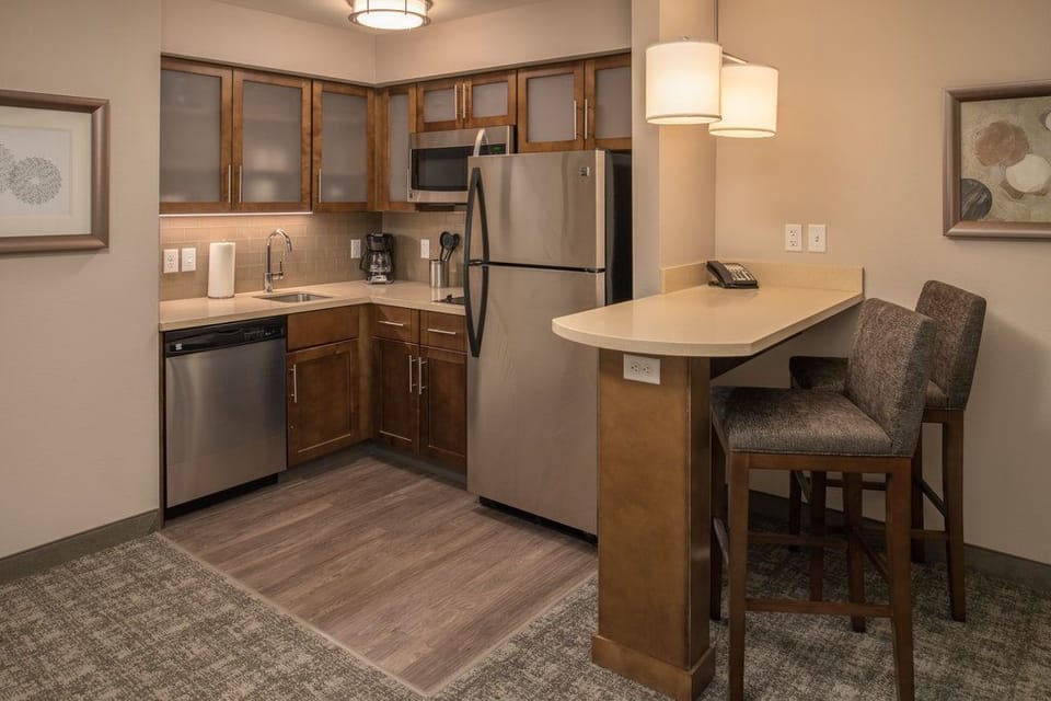 Kitchen with bar seating, stainless appliances, and cabinetry.