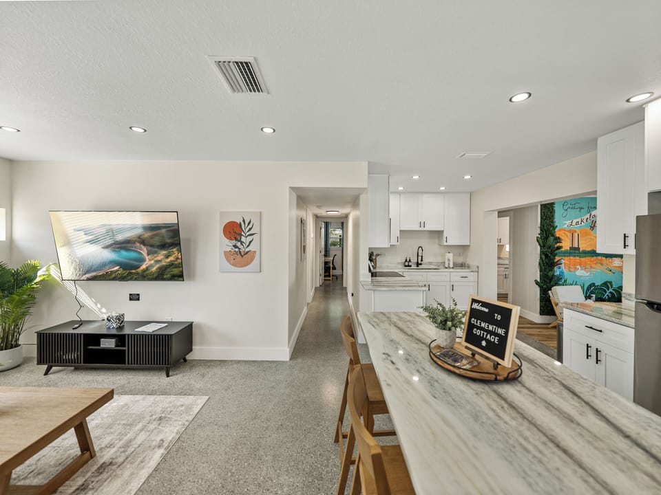 This open-concept kitchen blends style and functionality with a central island for meal prep and casual dining. Featuring modern stainless steel appliances, granite countertops, minimalist cabinetry, and perfect for everyday living.