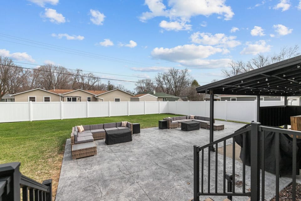 Fully fenced private backyard retreat with ample seating and a sheltered grill area.