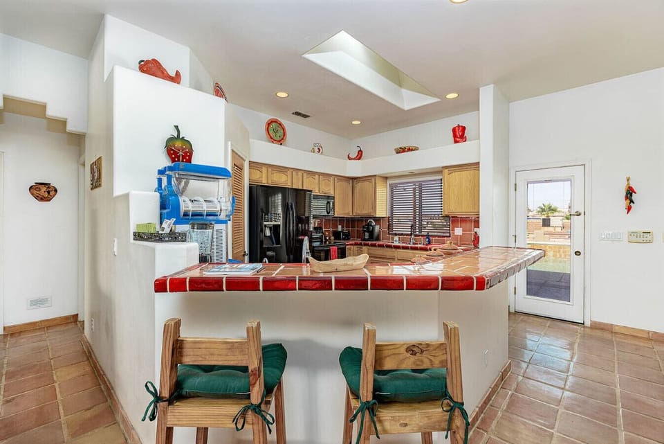 Fully equipped kitchen with colorful tile counters and bar seating