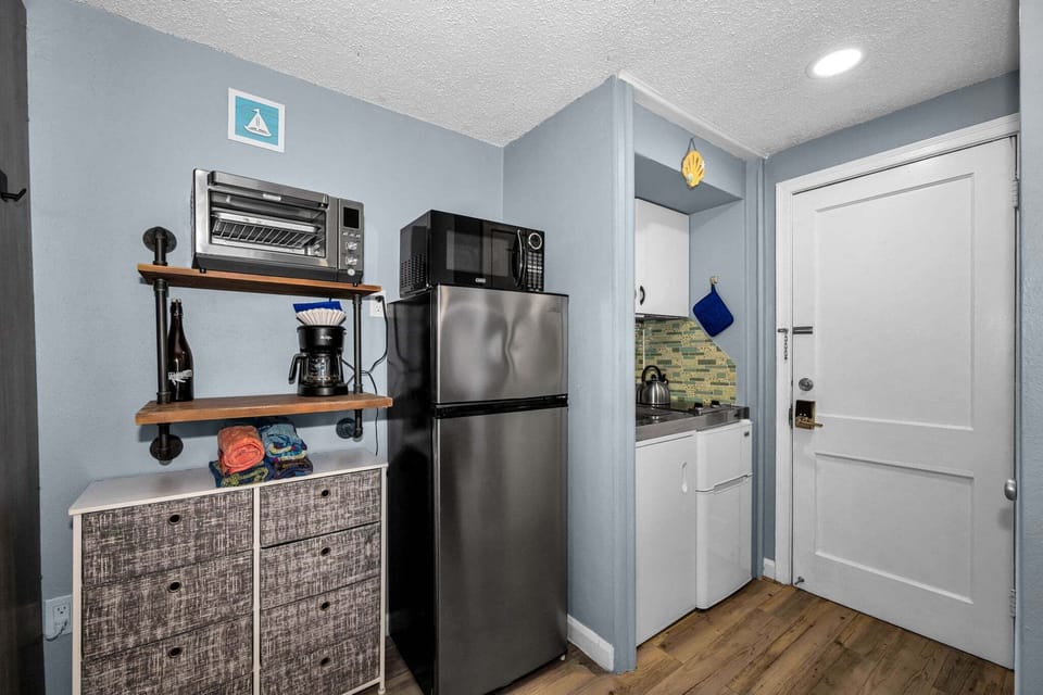 A compact but functional kitchenette with a two-burner stovetop, sink, and mini fridge — ideal for whipping up quick meals between beach trips.
