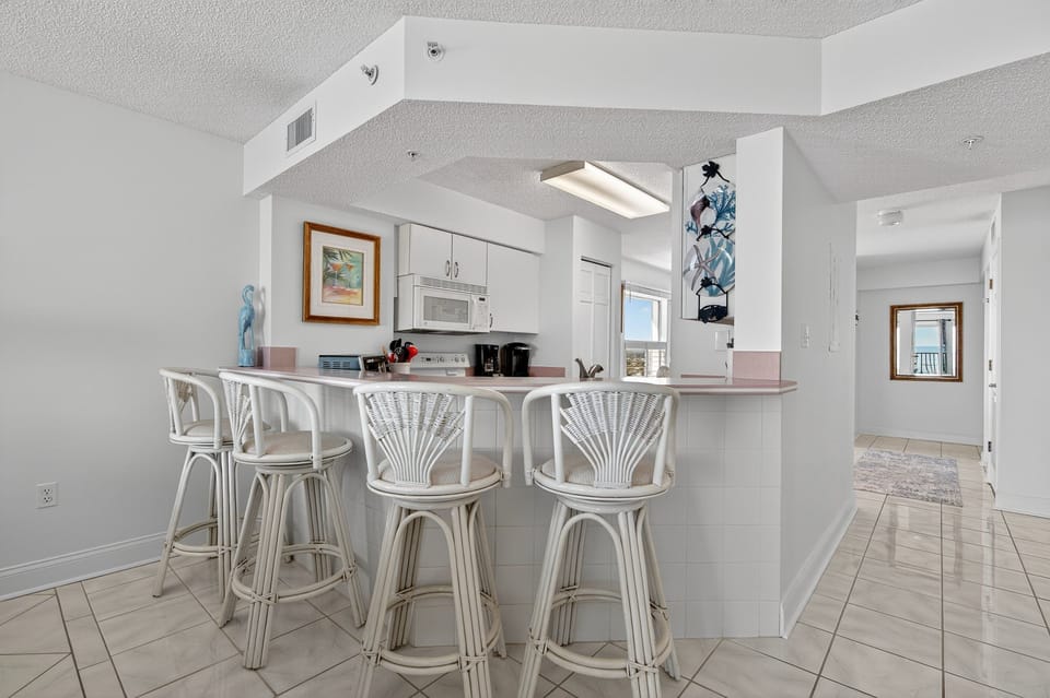 Add extra seating with bonus barstools at the kitchen counter. Perfect for casual meals or chatting while you cook in this oceanfront condo