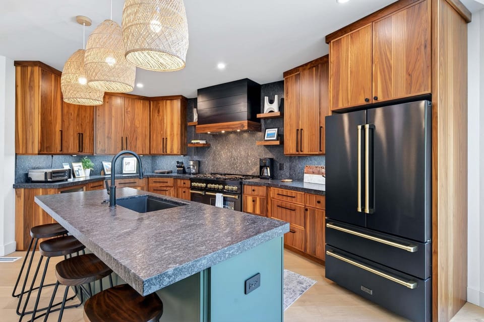 Kitchen with gas range, island, dishwasher, and multiple coffee options (standard drip-style, French press, and coffee grinder).