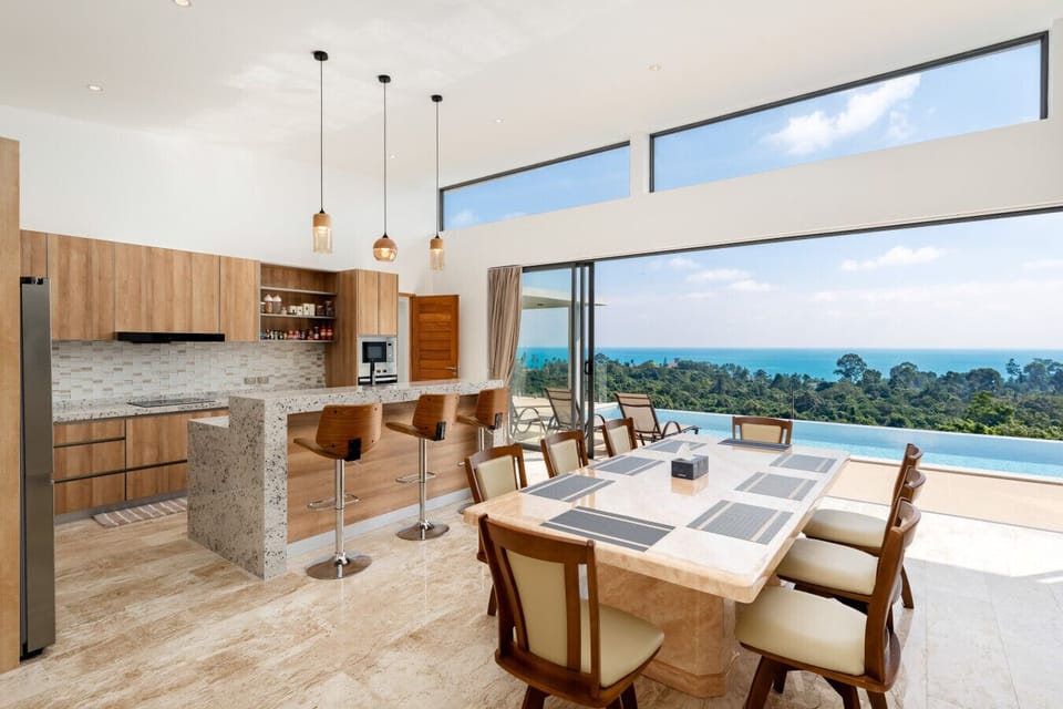 Bright open-plan kitchen and dining area with sea views — perfect for shared meals in paradise.