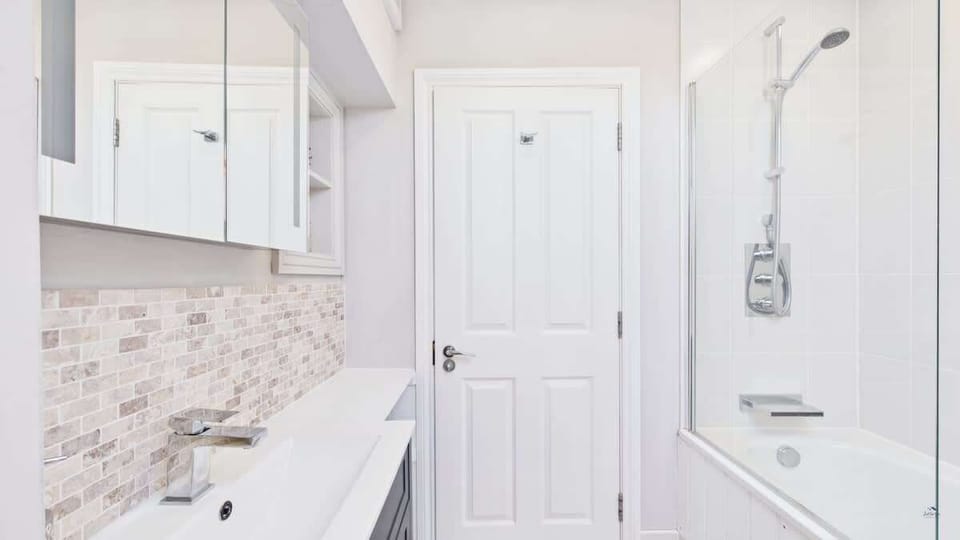 A second perspective of the bright family bathroom, highlighting the sleek tiling and contemporary vanity unit.