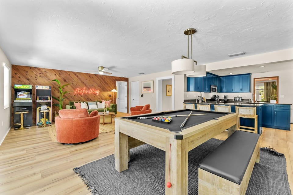 A fun-filled retreat awaits! Enjoy the ultimate game room featuring a 2-in-1 pool and ping pong table, arcade games, and an open floor plan that flows seamlessly into the kitchen—perfect for entertaining and making memories!