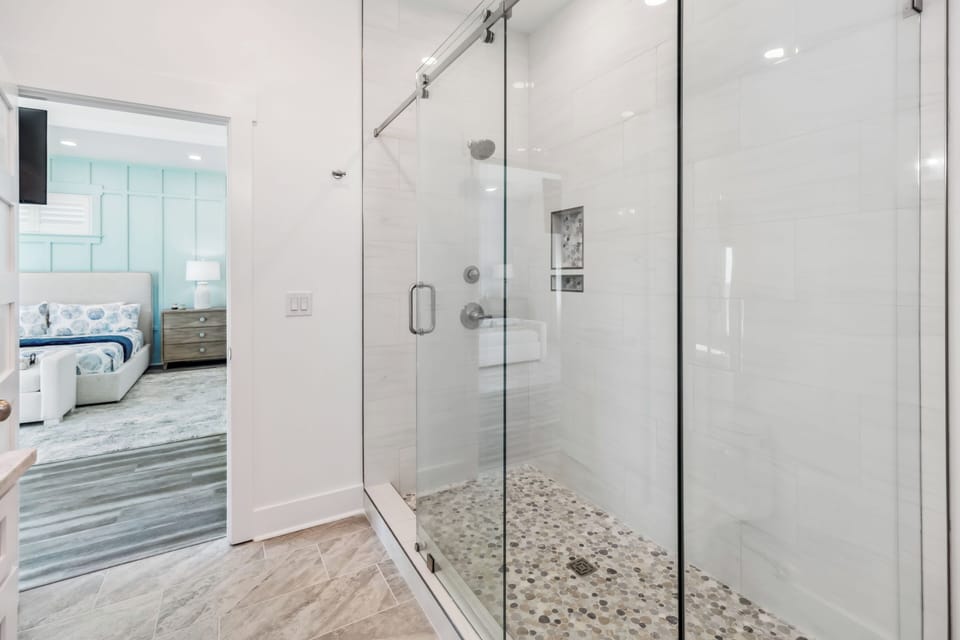 Step into your spa-like glass shower with rainfall head and pebble floor, adjoining your serene bedroom retreat.
