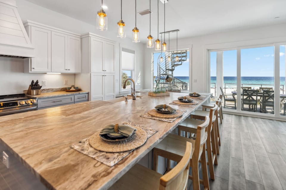 Your gourmet kitchen flows seamlessly to ocean views, where warm wood and elegant lighting create the perfect space for memorable meals.