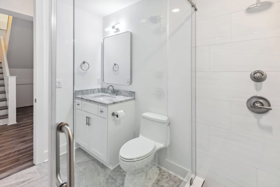 Unwind in your pristine bathroom featuring marble countertops, a spacious glass shower, and modern fixtures designed for your comfort.