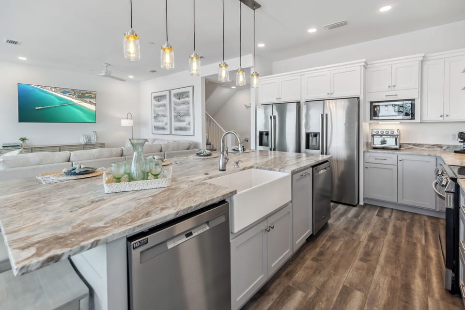 Gather with loved ones in this bright, open-concept space featuring a stunning kitchen island and elegant pendant lighting for memorable meals together.