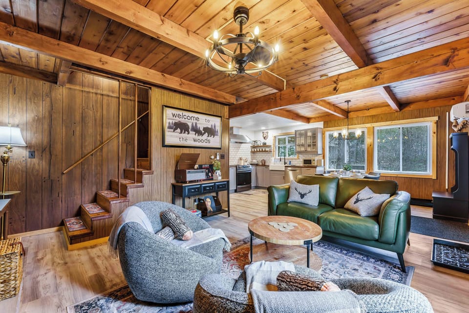 Embrace the warmth of this beautifully designed space, featuring wood-beamed ceilings, a cozy lounge, and an open flow into the kitchen and dining area - perfect for unwinding, entertaining, and soaking up the cabin vibes.