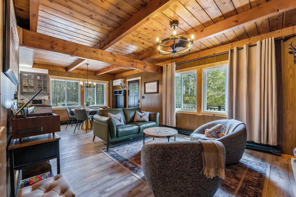 With soaring wood-beamed ceilings, large sun-filled windows, and an open-concept design, this inviting space effortlessly connects the living, dining, and kitchen areas - ideal for relaxing, entertaining, and enjoying time together in the mountains.