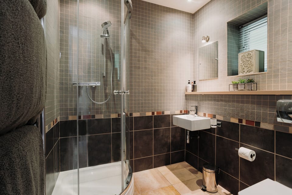 Bedroom 1's en-suite bathroom - Indulge in a revitalizing shower that refreshes your stay!