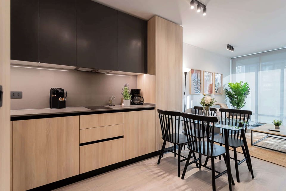 Experience modern living in this stylish kitchen, featuring sleek cabinetry and a cozy dining area perfect for meals and gatherings.
