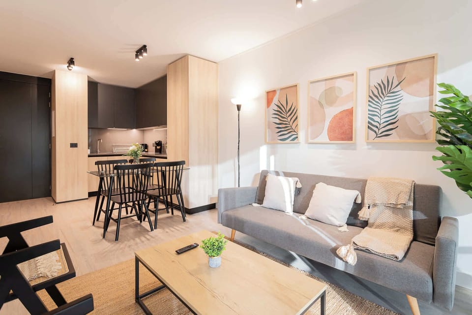 Experience modern comfort in this stylish living space, featuring a cozy sofa, dining area, and bright decor—perfect for your getaway!