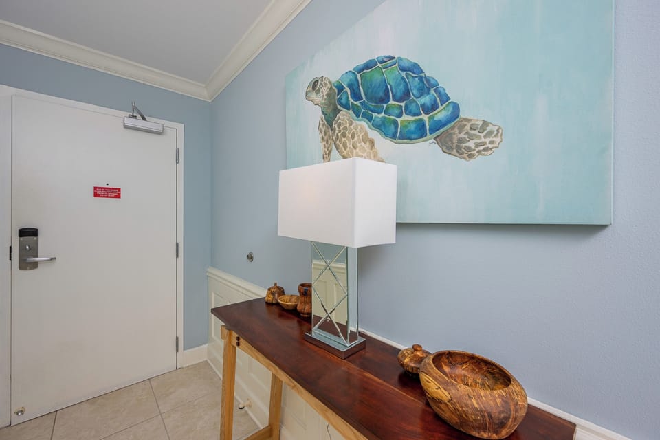 Step into a welcoming entryway adorned with coastal art, setting a serene mood for your beach getaway