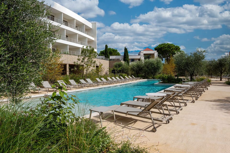 Spacious outdoor pool surrounded by lush Mediterranean greenery—perfect for a refreshing dip under the sun.