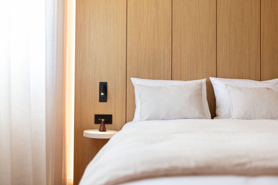 Contemporary guest room styled with wood panel accents and soft textures to evoke warmth and tranquility.