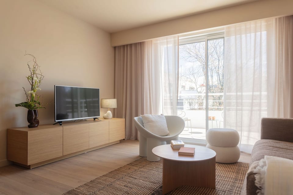Bright and airy living room with a flat-screen TV and calming garden views—designed for relaxation.