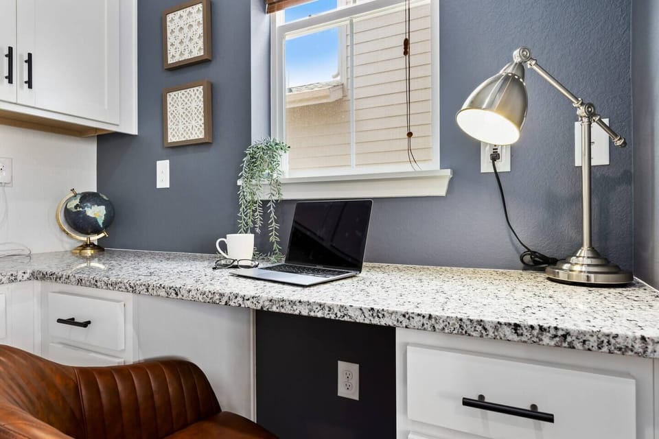 This dedicated workspace just off the kitchen offers a quiet, separate area with plenty of counter space, natural light, and all the essentials to stay productive—without being completely closed off from the rest of the home.