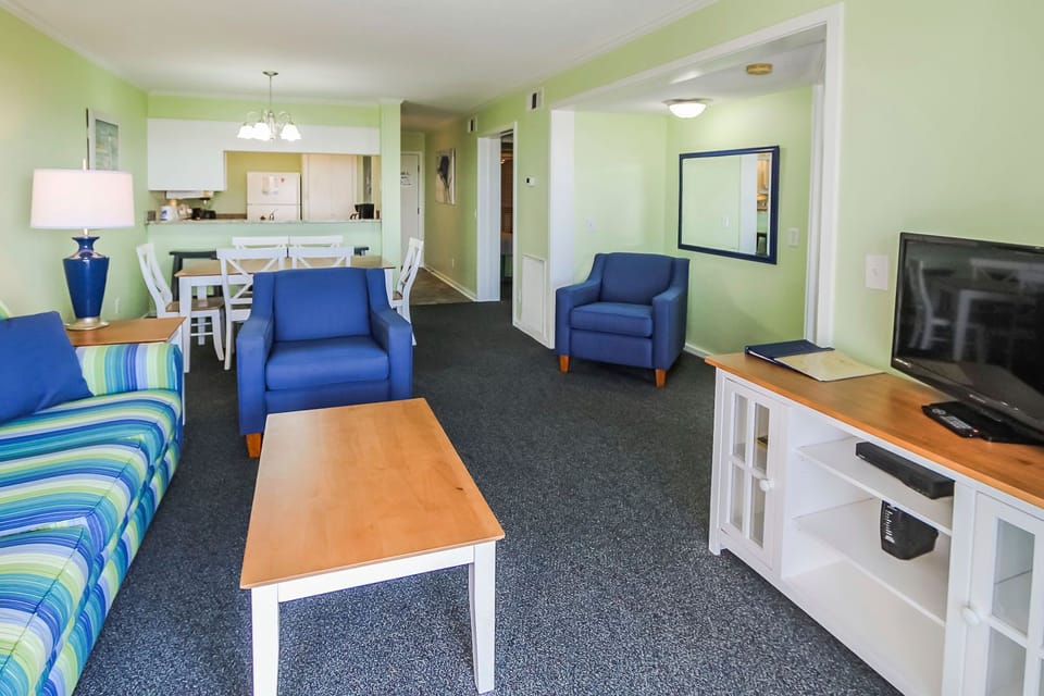 The bright and airy living area features comfortable furnishings and a TV, creating a perfect environment for family bonding after a day at the beach.