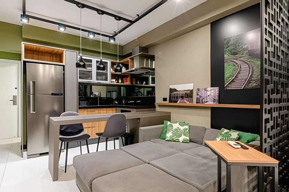 Sala/Cozinha - Sofá cama, balcão 2 cadeiras e geladeira.